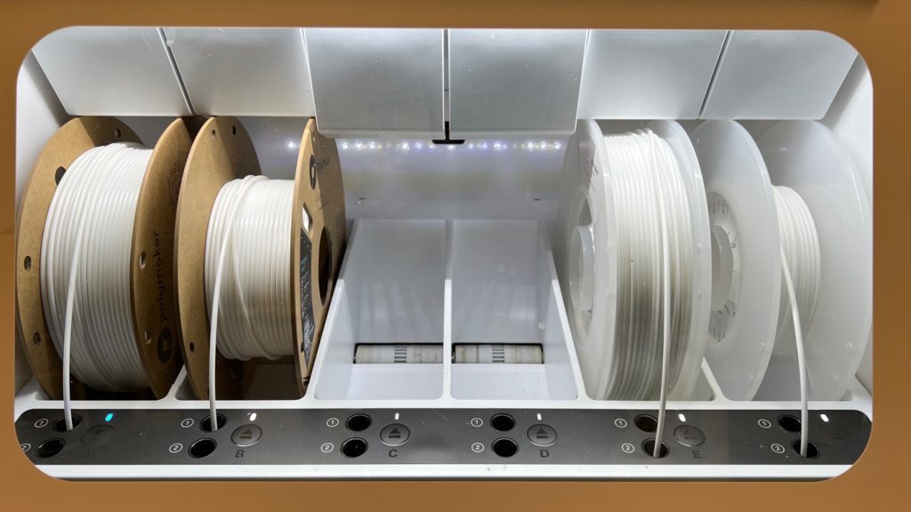 Image of 4 large spools of white plastic cable used for 3D printing.
